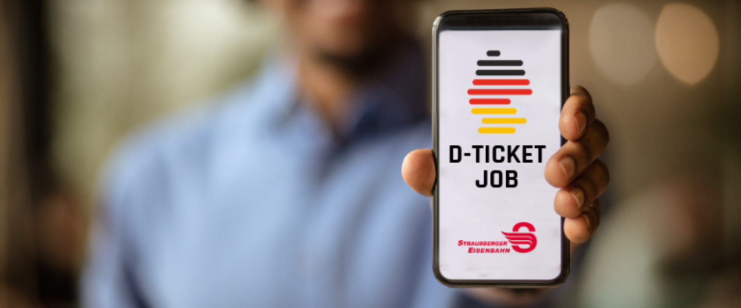 Mann hält Handy in Kamera auf dem Deutschlandticket Job von STE sichtbar ist